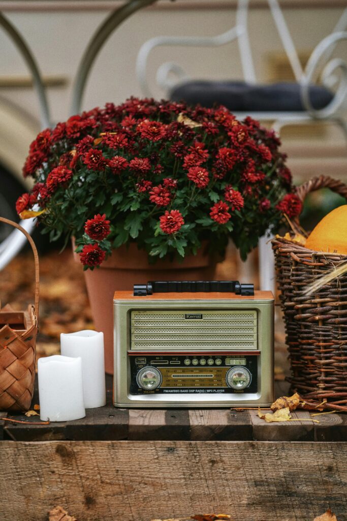 Estilo de decoração vintage com rádio, cestas e vaso com flores, em bancada amadeirada.