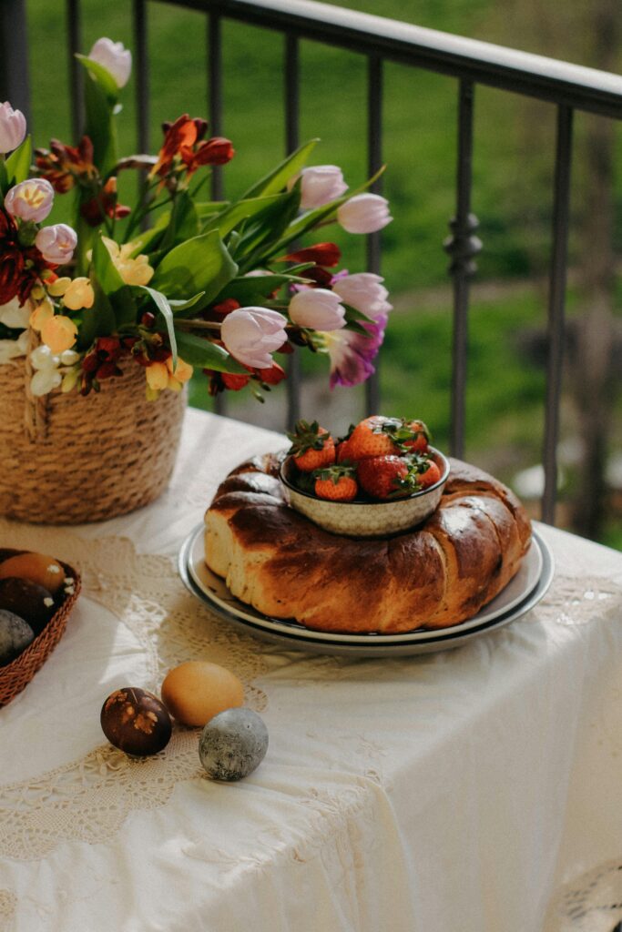 Mesa externa com cesta de palha com flores e tulipas.