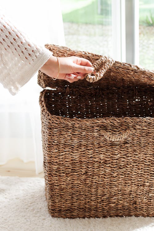 Cesto de material natural com tampa para guardar roupas ou objetos, um dos itens curingas para organizar a casa.