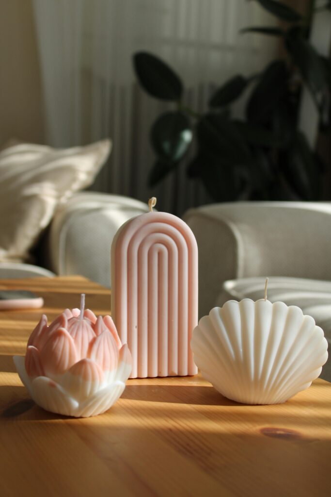 Lindas velas decorativas nas cores branca e rosa, nos formatos concha, pinha e oval.