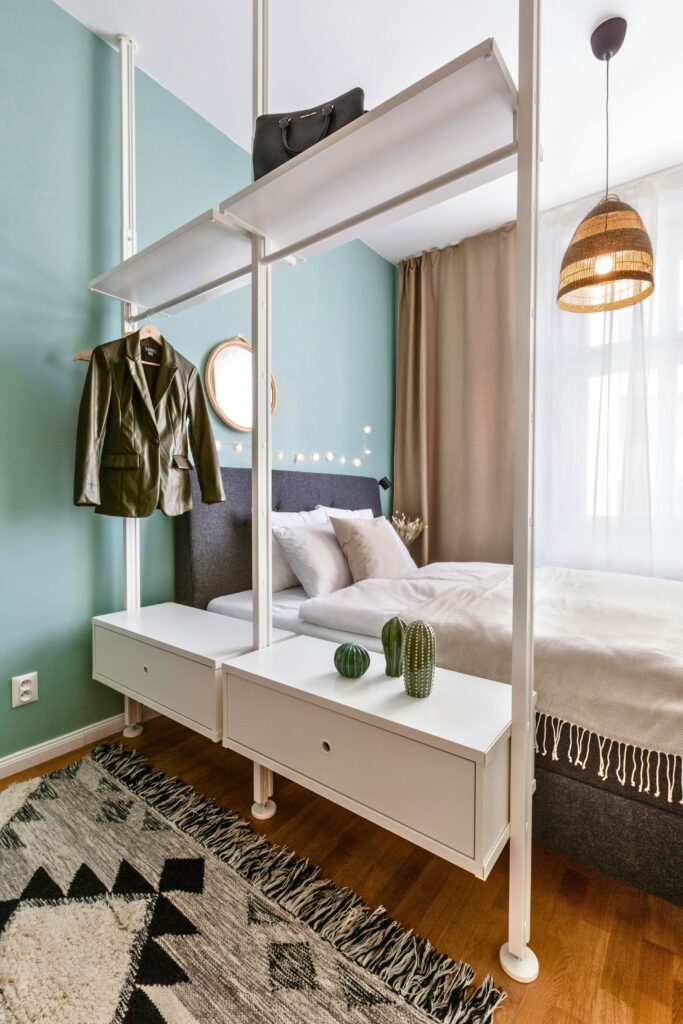  Como organizar um quarto pequeno com arara multifuncional, e gaveteiros integrados ao pé da cama.
