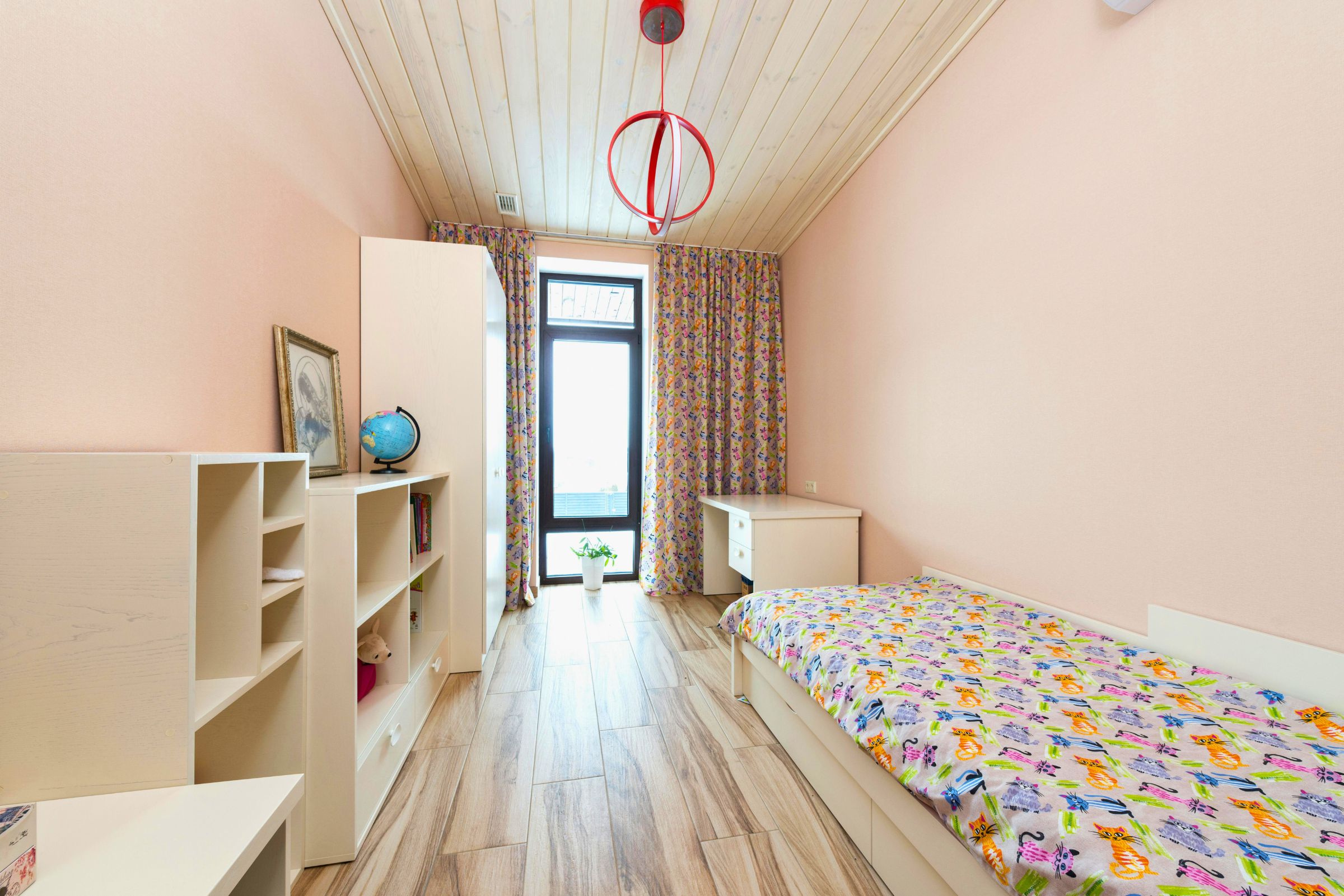 Quarto pequeno com móveis claros e estante baixa para organização inteligente