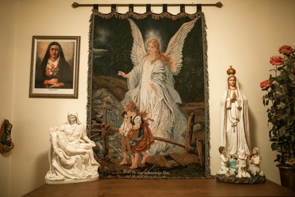 Cantinho da oração em casa com tapeçaria do anjo da guarda e imagens católicas