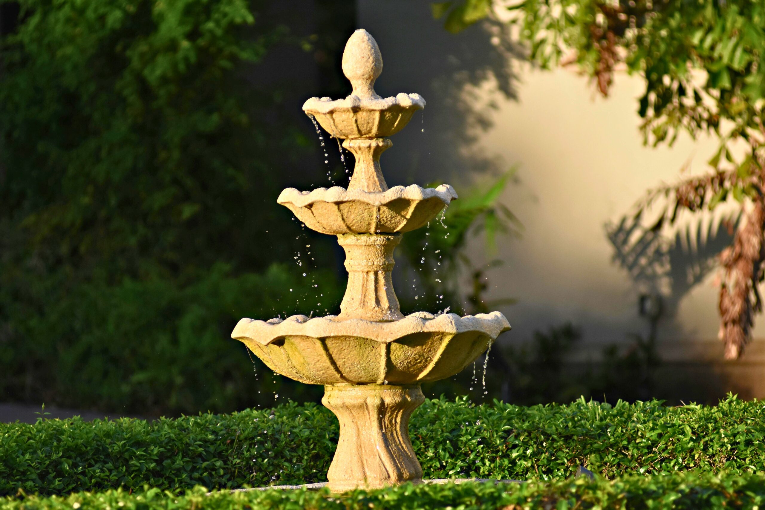 Fonte de água decorativa em jardim com design clássico de pedra