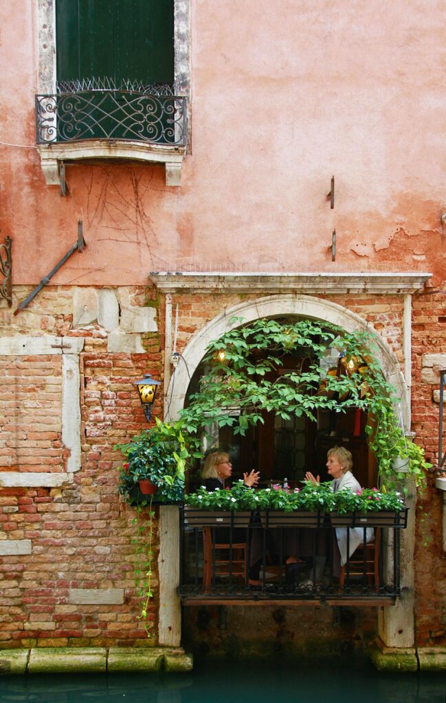 Conversas tranquilas em uma sacada italiana florida, representando a essência da dolce vita italiana.