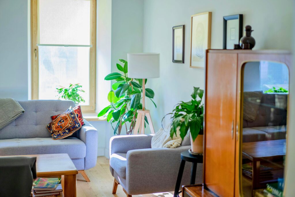 Sala aconchegante com luz natural, plantas, poltronas suaves e detalhes decorativos que criam um lar acolhedor