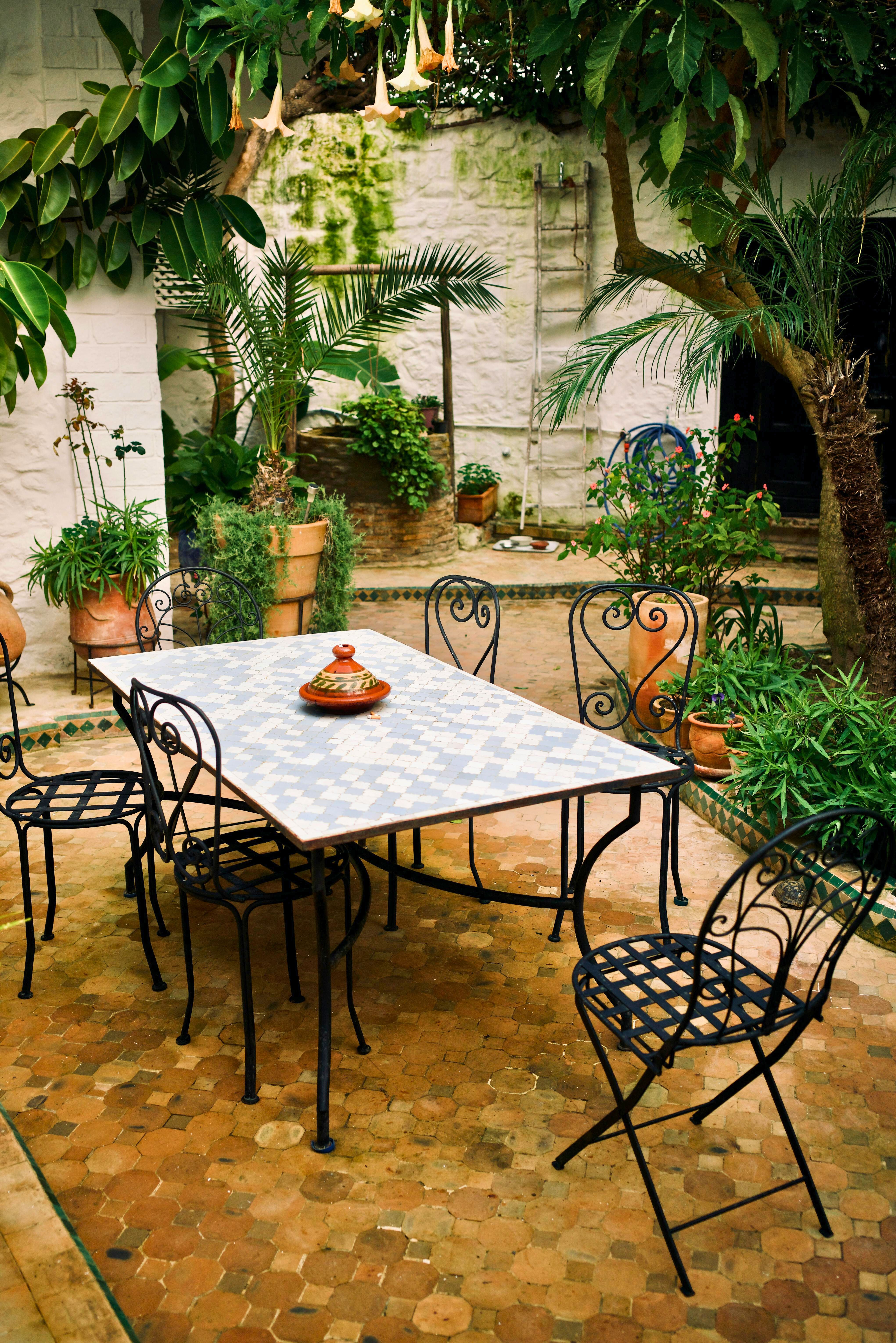 jardim integrado à casa com mesa externa, vasos de plantas e ambiente acolhedor inspirado na Itália